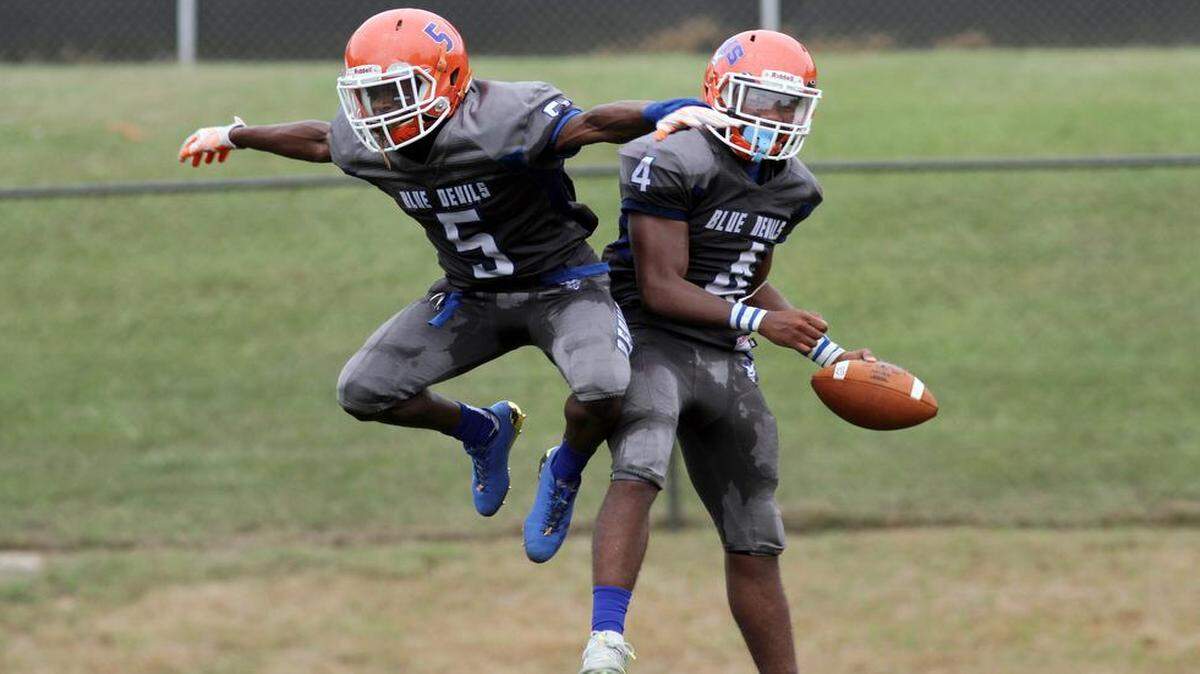 Columbus’ Caleb Bailey (5) and Darius Hill (4) celebrate after one of many big plays for the Blue Devils against Jordan on Saturday, August 26, 2017.