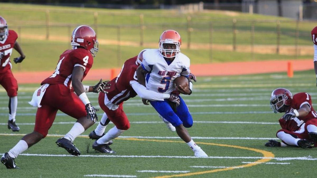 Columbus High QB Caleb Bailey tries to get past several Jordan defenders, including Jaden Jordan (4) and George McElroy (8) in the first half Friday night at Kinnett Stadium.