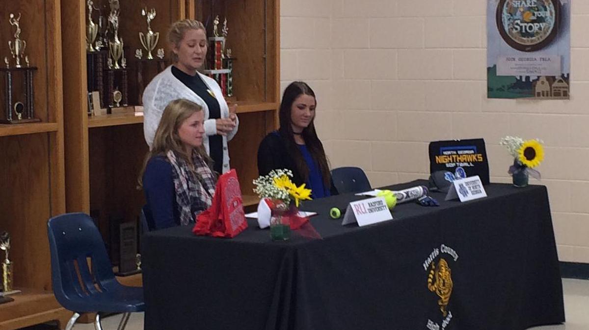 Harris County softball coach Brook Zuerner, center, talks about Lilly Hooper, left, and Brooke Wakenigg. Both signed Friday to continue their playing careers in college.