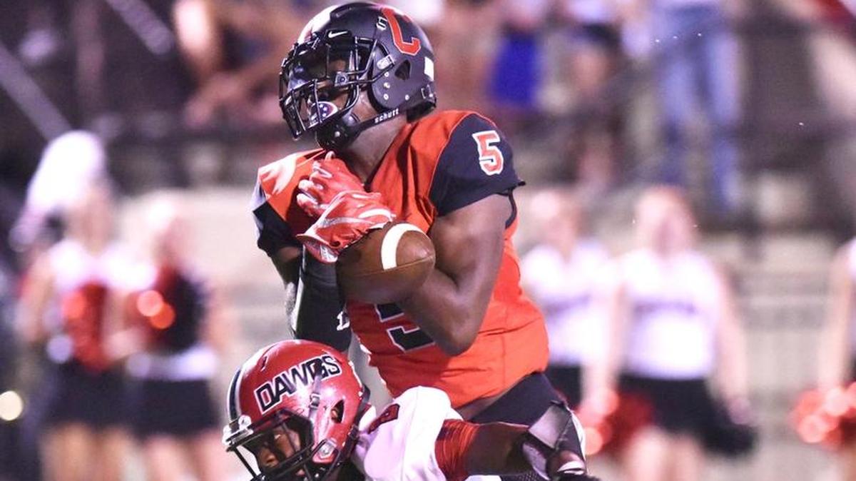 Central's Justyn Ross goes up and over Opelika's Justin Lewis for the pass reception and dives into the end zone against Opelika.