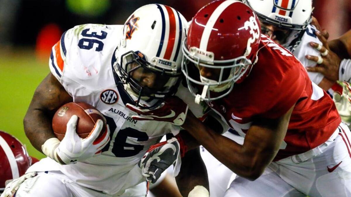Auburn running back Kamryn Pettway (36) is tackled by Alabama defensive back Levi Wallace (39) as he carries the ball during the second half of the Iron Bowl NCAA college football game, Saturday, Nov. 26, 2016, in Tuscaloosa, Ala. (AP Photo/Butch Dill)