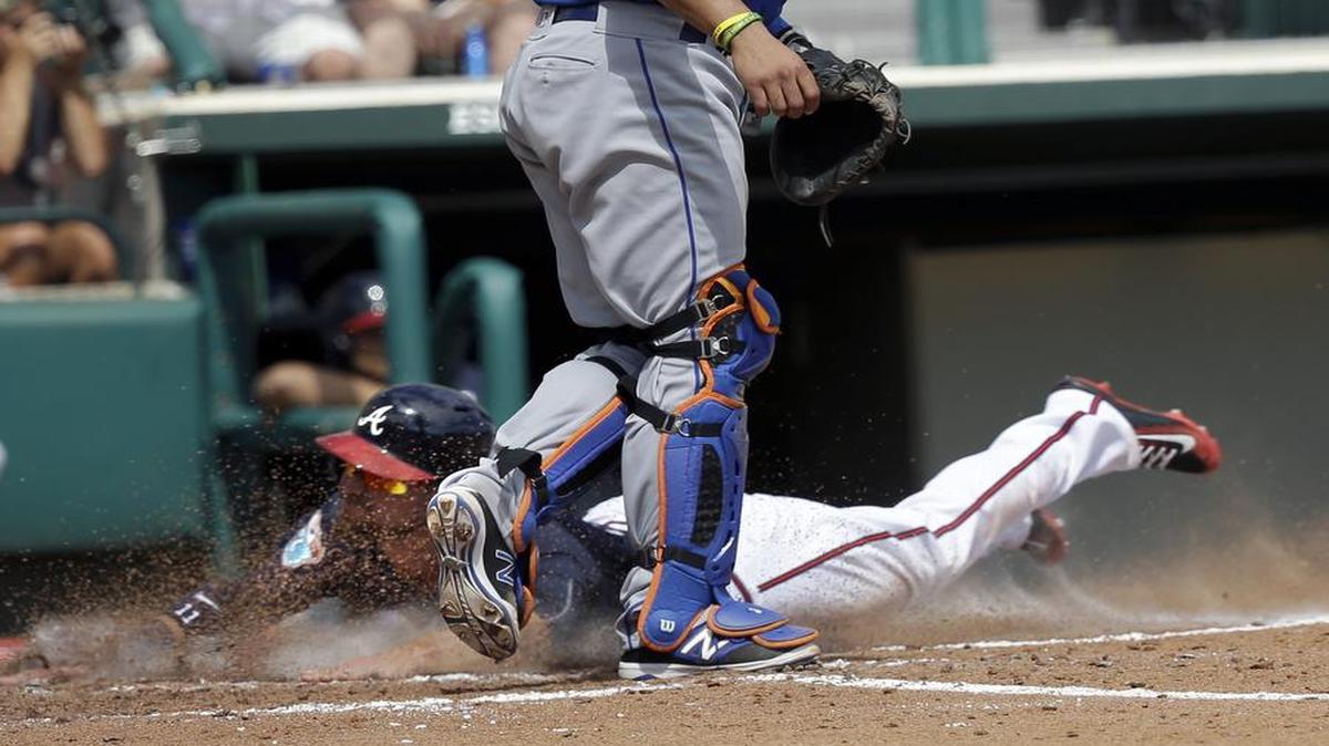 Atlanta Braves' Ender Inciarta, lower left, slides in home as New York Mets catcher Johnny Monell waits for the throw in the third inning of a spring training baseball game, Tuesday.