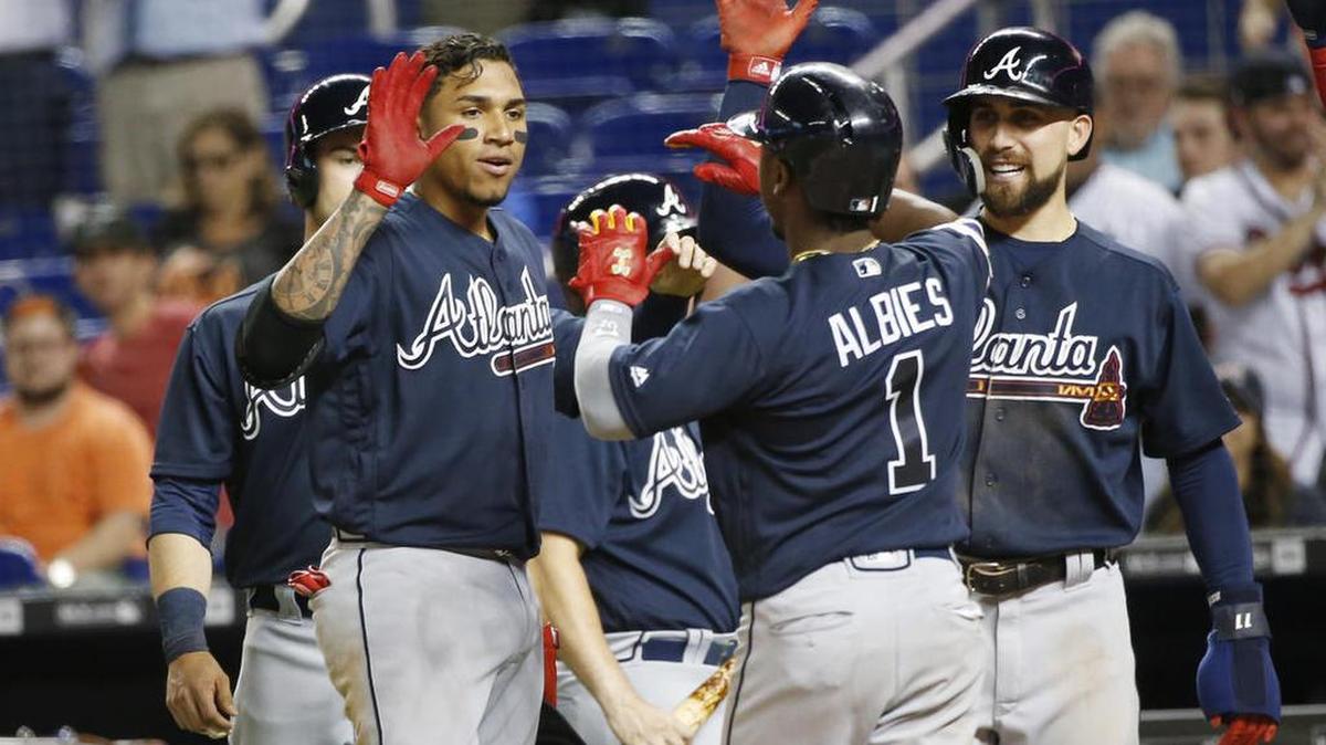 Atlanta Braves' Ozzie Albies (1) celebrates with teammates after hitting a grand slam, scoring Preston Tucker, left rear, Johan Camargo, second from left, and Ender Inciarte, right, during the sixth inning of a baseball game against the Miami Marlins, Thursday, May 10, 2018, in Miami.