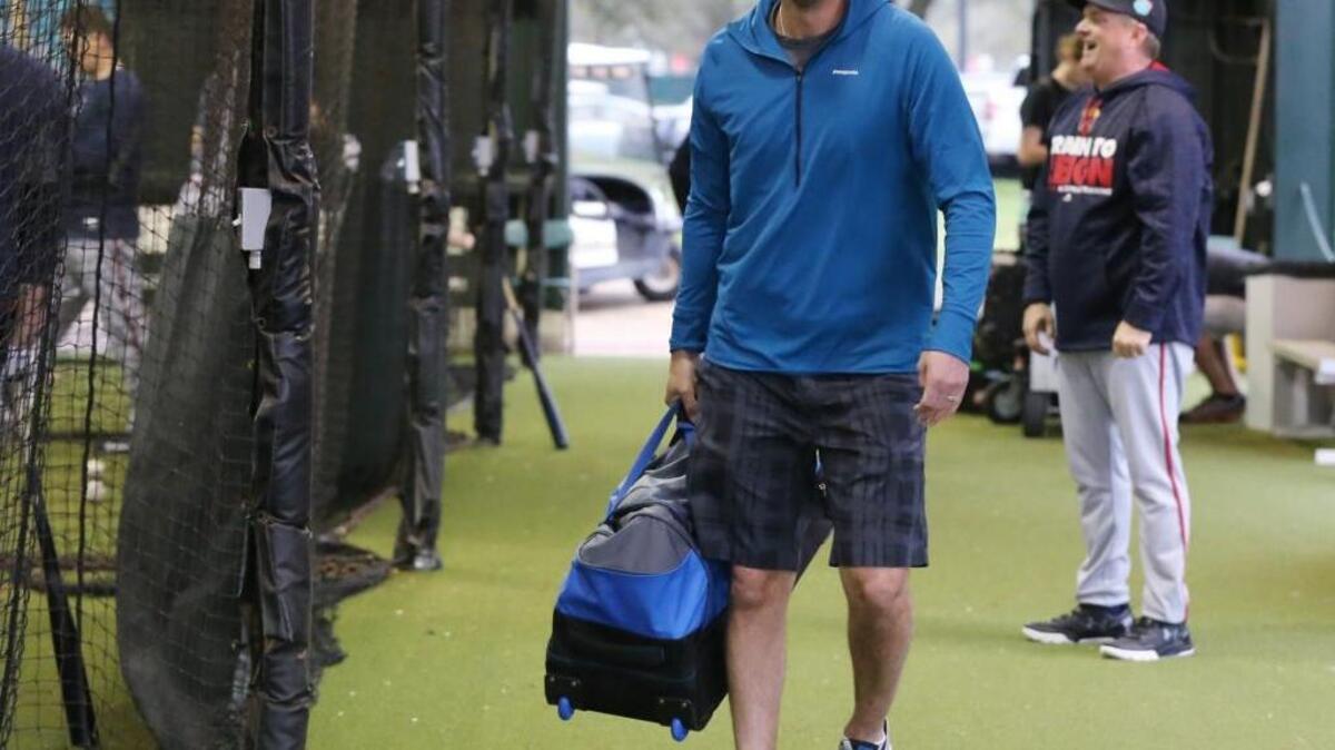 Braves outfielder Jeff Francoeur smiles as he walks through the batting cages as he arrives with his bag of gear for his first day of spring training baseball practice last month.