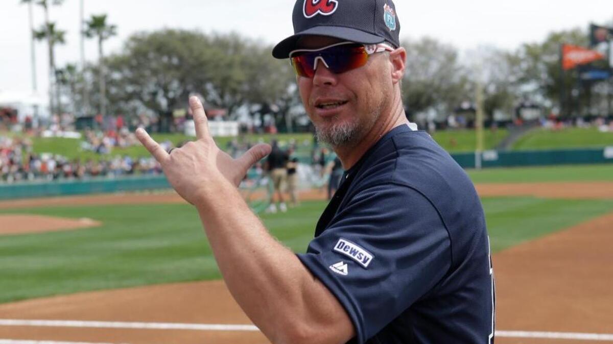 Former Atlanta Braves third baseman and currently a special assistant to baseball operations Chipper Jones flashes a sign to fans as he walks to the dugout before Friday’s game.