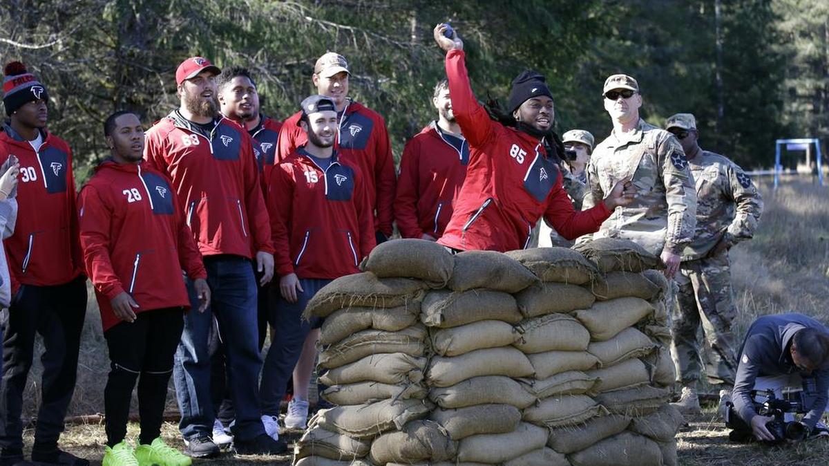 Atlanta Falcons’ J.D. McKissic (Central) tosses a practice hand grenade as he and teammates are given a hands-on orientation of training for U.S. Army soldiers working to earn an Expert Infantry Badge on Tuesday at Joint Base Lewis McChord, Wash. Ten players from the active and practice rosters visited the base to view the training, weapons, crawl into and atop a Stryker combat vehicle and sign autographs. Atlanta plays the Seattle Seahawks on Sunday in Seattle.