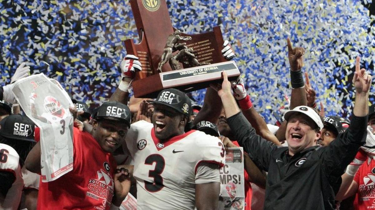 University of Georgia head coach Kirby Smart, right, and game MVP Roquan Smith, center, hold the championship trophy after the Bulldogs beat Auburn 28-7 to take the SEC Championship at Mercedes Benz Stadium in Atlanta Saturday.