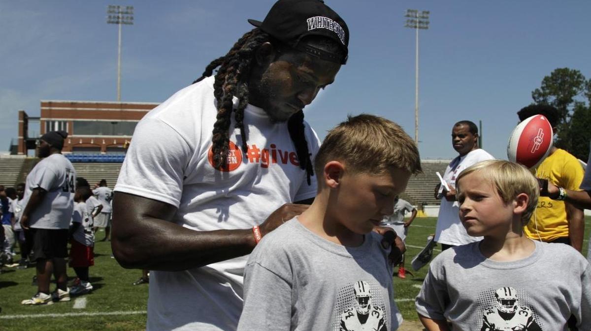 Cleveland Browns running back and Columbus native Isaiah Crowell autographs the camp t-shirts on Connar Kloehn, 9, and Marshall Gallatin, 10, right, during his second annual football camp at the A.J. McClung Memorial Stadium. Crowell donated 100 turkeys to needy residents Tuesday at South Columbus United Methodist Church.
