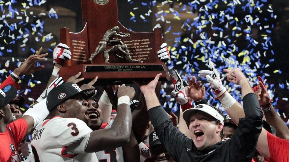 University of Georgia's Roquan Smith, left, and head coach Kirby Smith hold the SEC Championship trophy after the Bulldogs beat Auburn 28-7 to take the SEC Championship at Mercedes Benz Stadium in Atlanta Saturday. Smith was named the MVP.