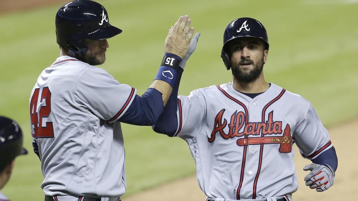 Atlanta Braves’ A.J. Pierzynski, left, high-fives Nick Markakis after both scored on base hit by Adonis Garcia during the eighth inning of a baseball game against the Miami Marlins, Friday, April 15, 2016, in Miami. The Braves won 6-3.