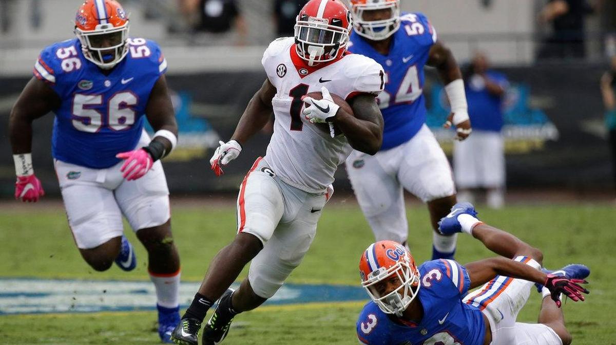 Georgia's Sony Michel (1) runs past Florida defenders including defensive lineman Tedarrell Slaton (56) and cornerback Marco Wilson (3) for a 45-yard touchdown in the second half of an NCAA college football game, Saturday, Oct. 28, 2017, in Jacksonville, Fla. Michel finished with 137 yards rushing on just six carries. Georgia won 42-7. (AP Photo/John Raoux)