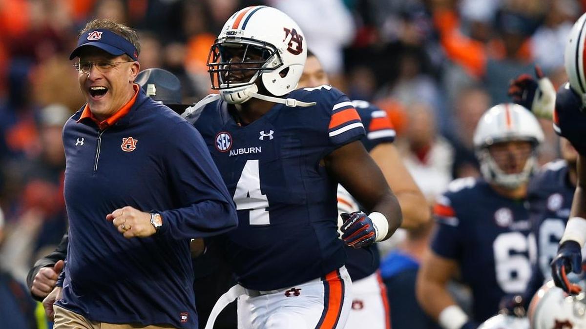 In this Nov. 11, 2017, file photo, Auburn head coach Gus Malzahn runs off the field after the first half of an NCAA college football game against Georgia in Auburn, Ala.