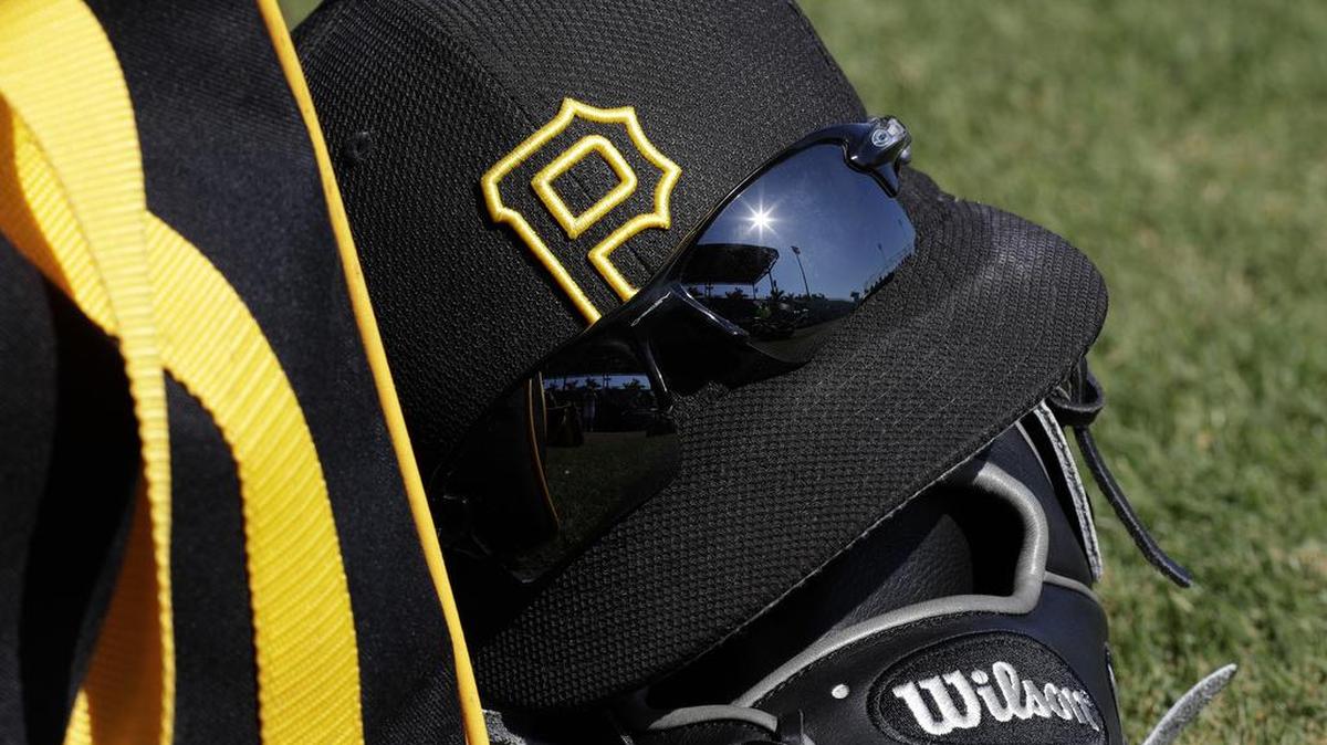 A Pittsburgh Pirates hat and glove sit on the field before a spring training baseball game against the Tampa Bay Rays on Friday. Columbus native Jimmy Lester has been a scout for the past 15 years with the Pirates.