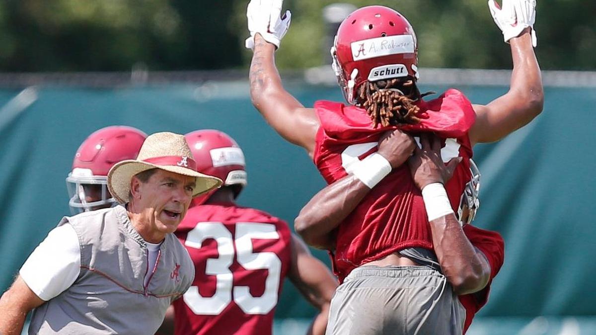 Alabama coach Nick Saban, left, instructs defensive back Aaron Robinson, right, during practice on Thursday.