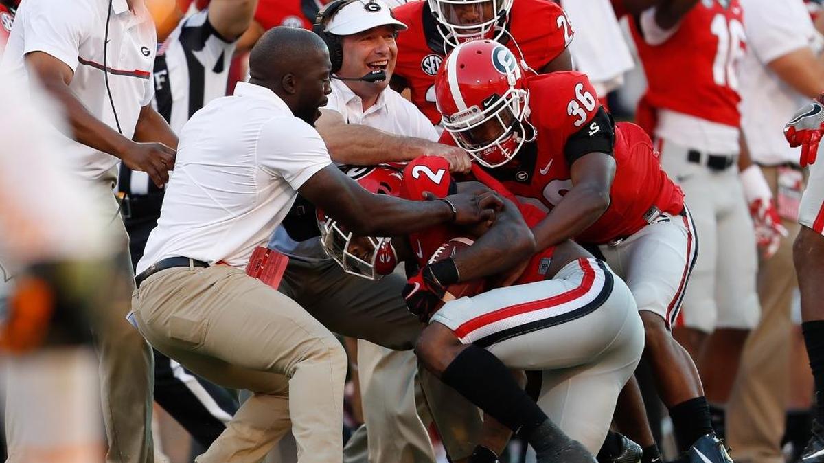 Georgia head coach Kirby Smart, center, helps Georgia defensive back Maurice Smith (2) to his feet after he intercepted a pass in the second half Saturday.