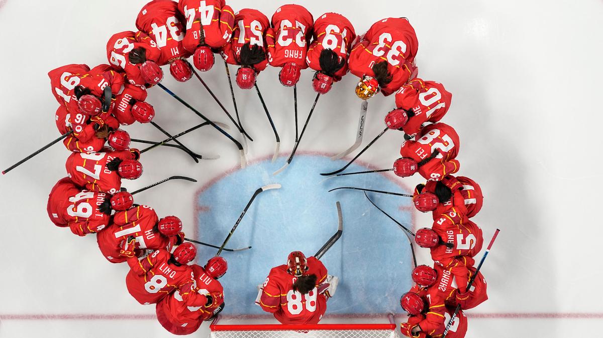 The Chinese team gathers around goalkeeper Tiya Chen before a women’s hockey game against Czech Republic at the 2022 Winter Olympics. The team is coached by Brian Idalski, who used to play for the Columbus Cottonmouths.