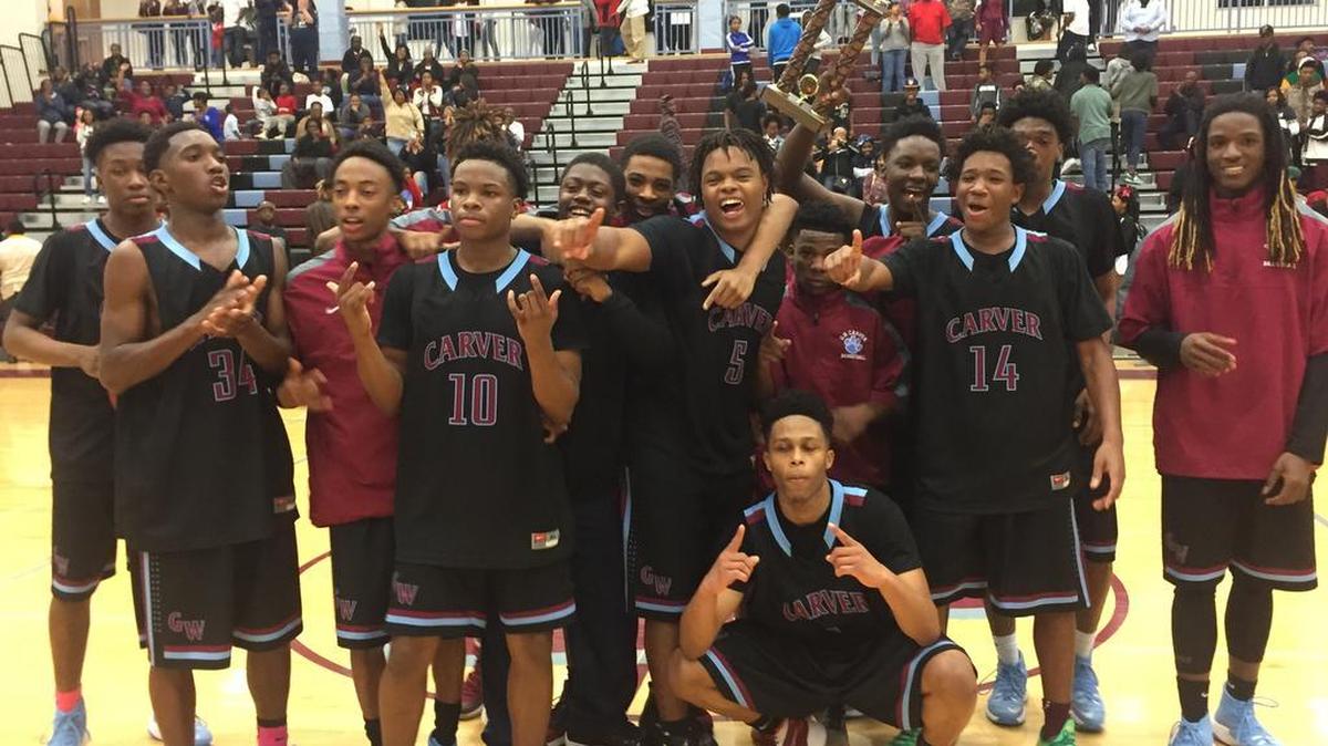 The Carver Tigers celebrate after winning the Region 1-4A boys basketball tournament.