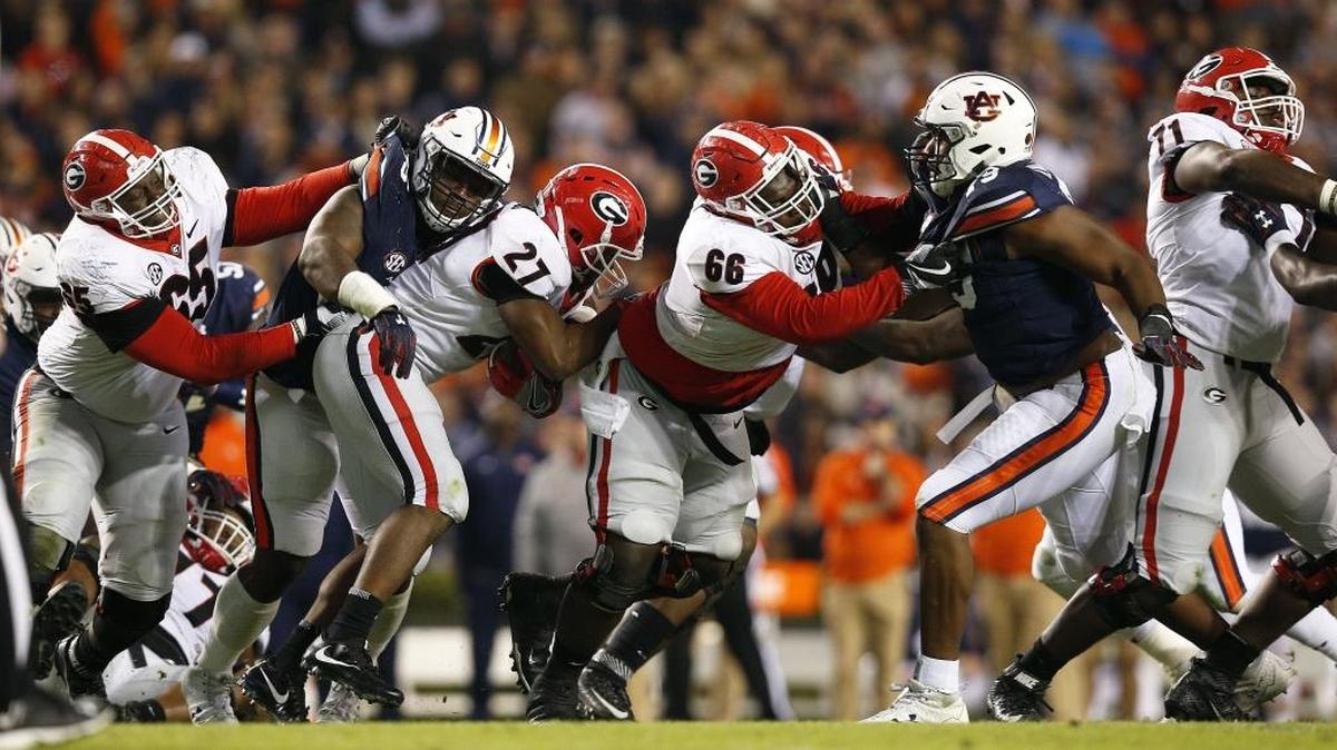 Auburn’s Dontavius Russell, second from left, tackles Georgia’s Nick Chubb (27) during their first game this season. Auburn’s defense shut down the Bulldogs’ running game, holding Chubb to 27 yards on 11 carries. Georgia finished the game gaining only 46 rushing yards.